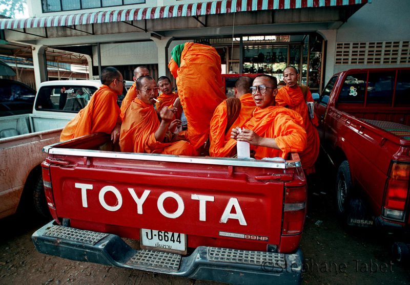 A monk's group travelling in a Toyota pickup box. Bangkok Thailand