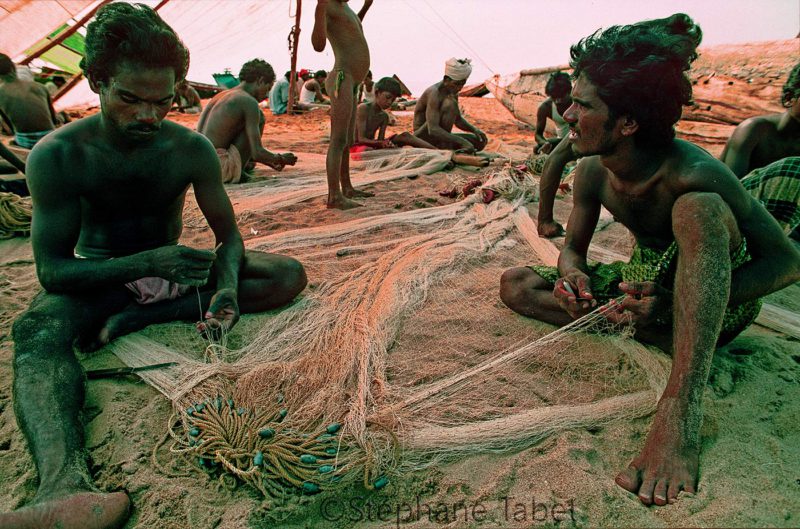 fishermen fixing fishing net